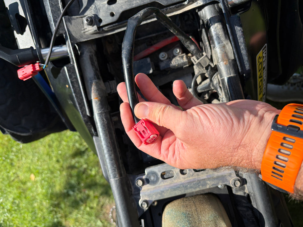 Locating the factory diagnostic plug beneath a Yamaha T7 seat for dongle fitting