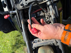 Locating the factory diagnostic plug beneath a Yamaha T7 seat for dongle fitting