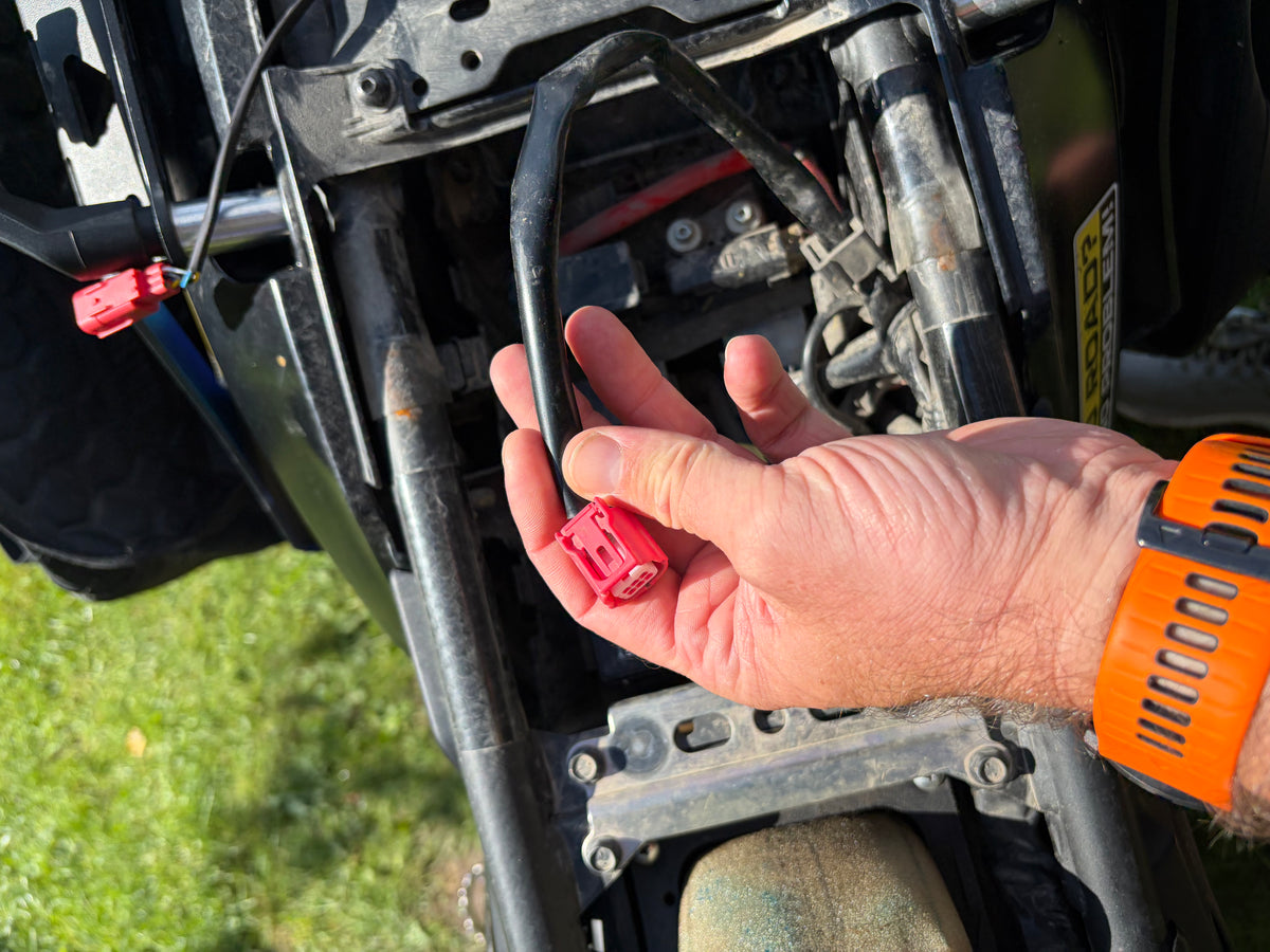 Locating the factory diagnostic plug beneath a Yamaha T7 seat for dongle fitting